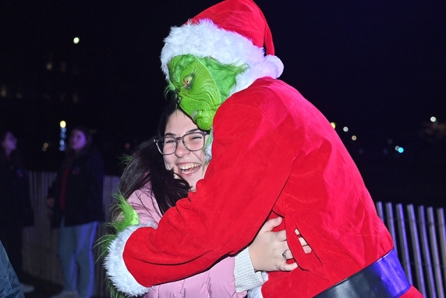 A group of students hugging at the St. John's Christmas tree lighting 