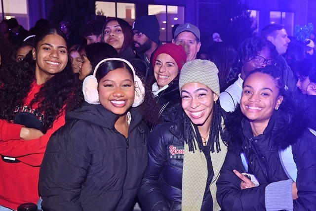 A group of students posing for a photo at the St. John's Christmas tree lighting 