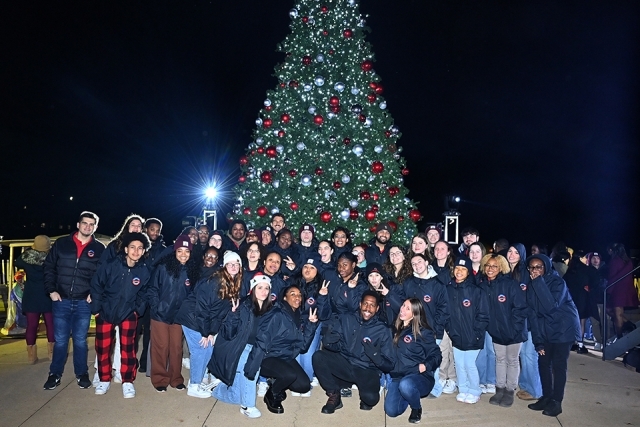 Three St. John's Students posing infront of Christmas tree