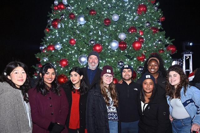 Three St. John's Students posing infront of Christmas tree