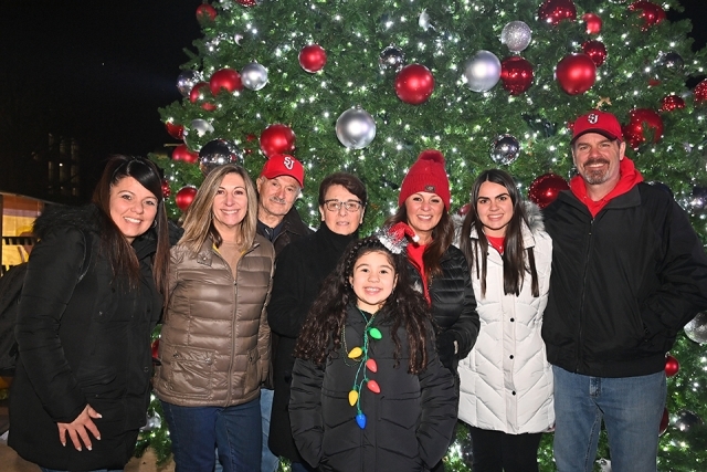 A group of St. John's alumni and family posing infront of Christmas tree