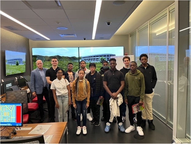 afterward_dr._chris_cleary_poses_for_a_group_photo_with_some_of_the_explorers_in_the_homeland_simulation_lab