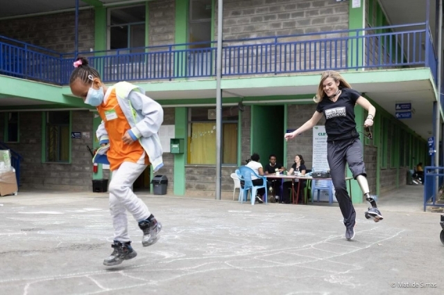 St. John's Law student Mary John's plays a hopping game in a coutyard with a little girl.