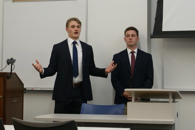 Two male Tobin students presenting at the front of the room