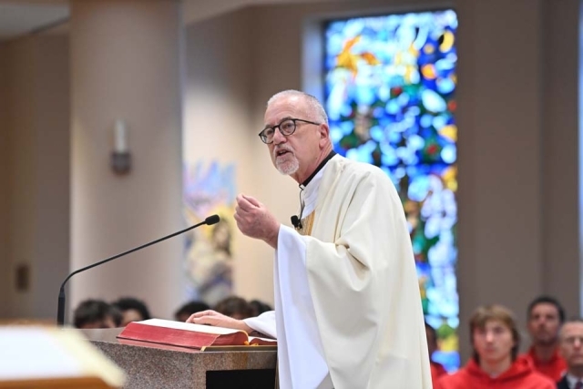 Fr. Rooney speaking at podium in church