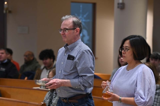 Stephen Vivona and woman presenting gifts of bread and wine in church