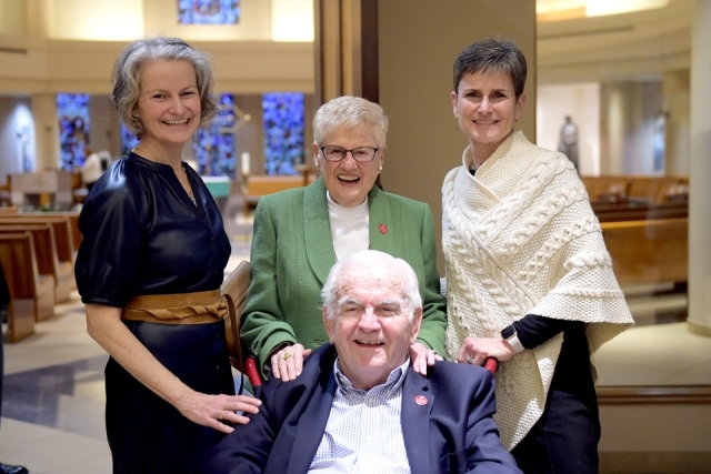 Three women and a man sitting pose for a photo