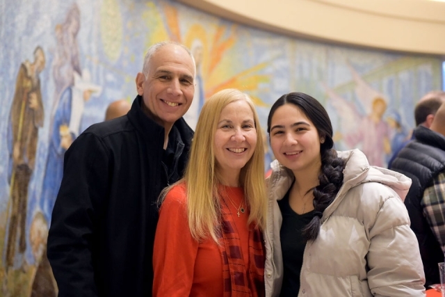 Man and two women posing for photo in church lobby