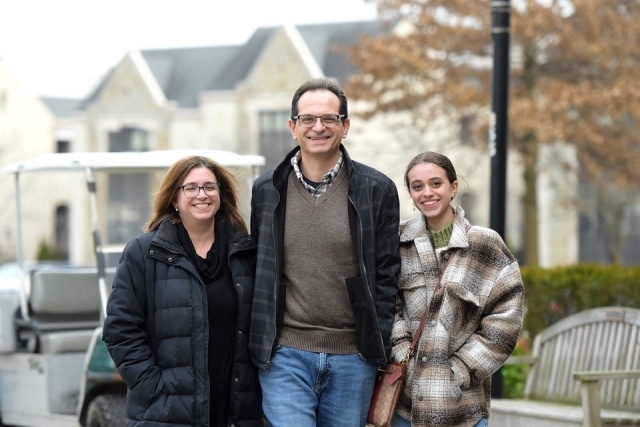 Three adults pose for a photo near Great Lawn