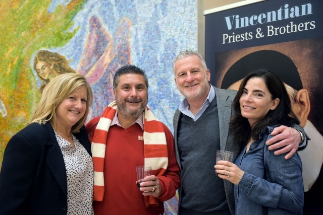Two couples pose for a photo inside of St. Thomas More Church