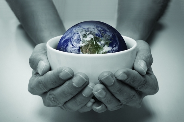 Black and white photo of hands holding a bowl with a colorful globe