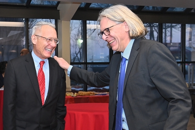 Simon Møller having a conversation with a man in a red tie