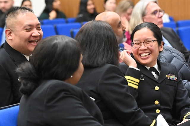 Attendees sharing a laugh in the theater