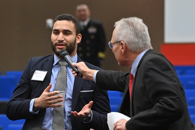 moderator holding the microphone for a man speaking