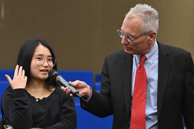 Moderator holding microphone for a woman