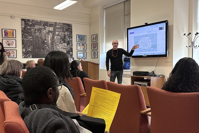 Students seated in a classroom watching projector screen