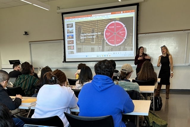 Students seated in a classroom watching projector screen