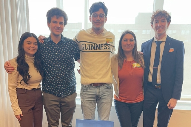 group of five students posing for a photo