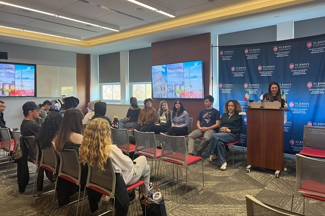Spectators watching a presentation with speaker at podium at front of room