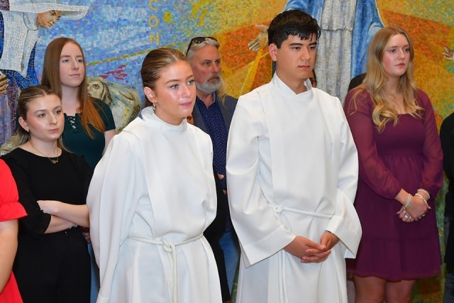 alter servers and RCIA ceremony attendees standing in church lobby