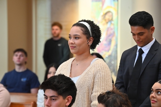 Inset of female and male student standing in church