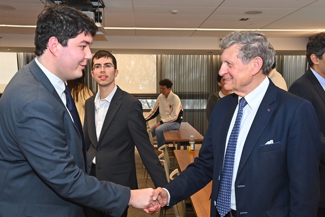  Leszek Balcerowicz, Ph.D. ’74CBA shaking hands of St. John's student 