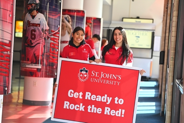 St. John's students hold a sign that reads, "get ready to rock the red, St. John's University."