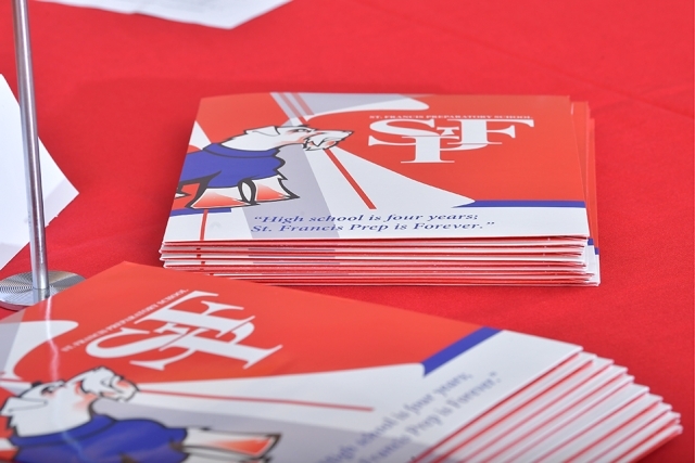 Stack of flyers and programs on red table