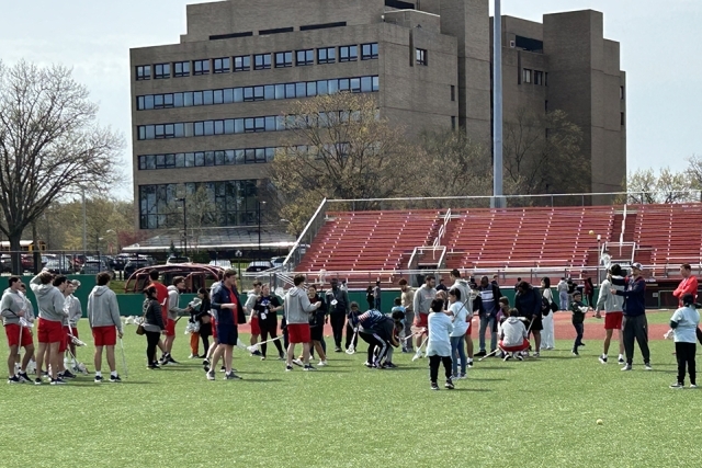 St. John's lacrosse players with special needs children on the field