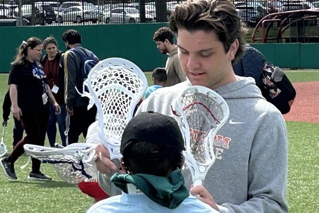 St. John's lacrosse player with special needs child on the field