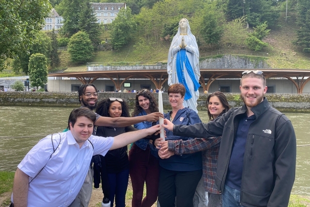 St. John's students on Plunge retreat pose for a group photo with Virgin Mary statue