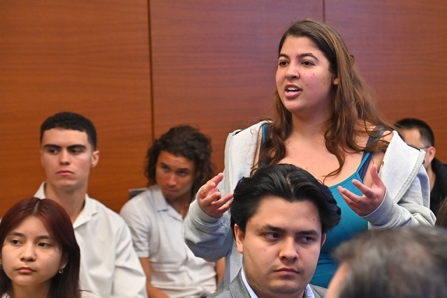 Female St. John's student rises from her seat to ask a question 