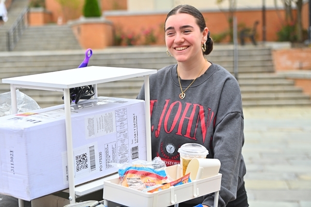 St. John's student rolling belongings on cart