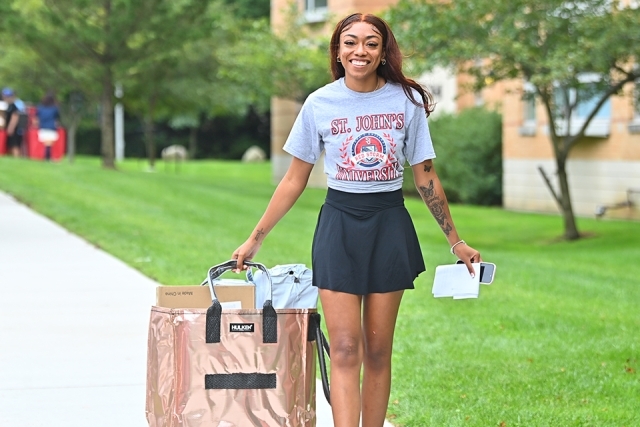 Female St. John's student walking with her belongings