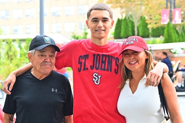 Male St. John's student poses for photo with his parents