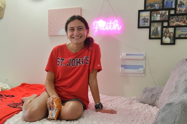 Student sitting on her bed in residence hall