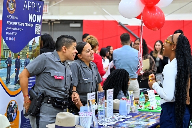 Student visiting table and interacting with NYSP reps