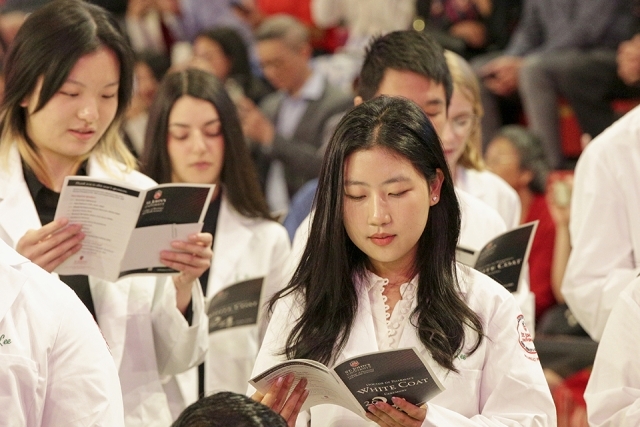 St. John’s University’s College of Pharmacy and Health Sciences reading the white coat ceremony program