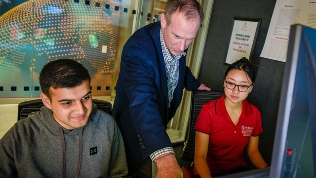 St. John's faculty teacher instructing students in the cyber lab