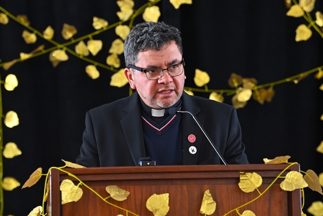 Priest speaking at podium