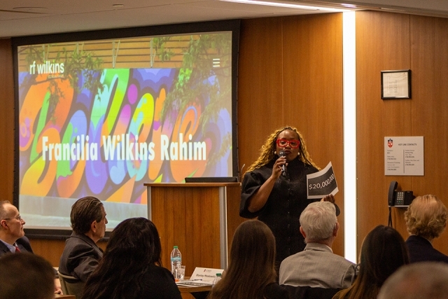 Female student presenting at James and Eileen Christmas Business Plan Competition