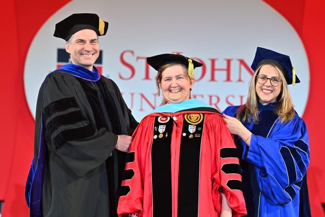 Christine M. Goodwin, '96C, '98G, '07PD, '21Ed.D.  being hooded at Commenceement