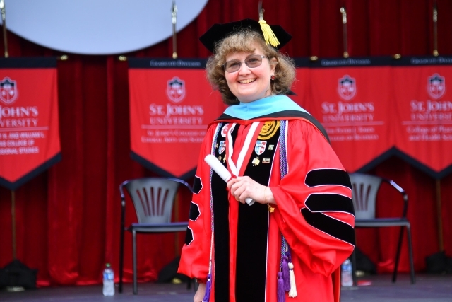 Christine M. Goodwin, '96C, '98G, '07PD, '21Ed.D. walking across the SJU Commencement Stage