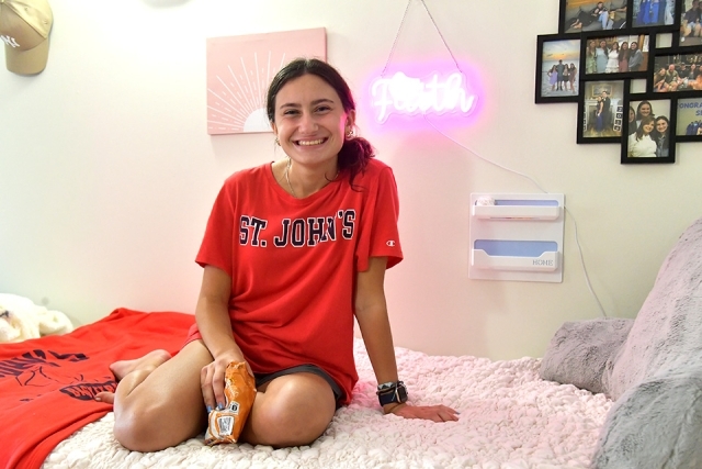 St. John's student sitting on her bed during move in 