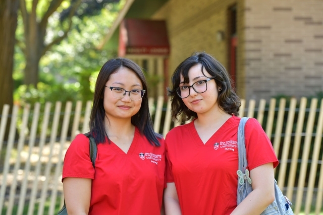 Two nurses in red scrubs