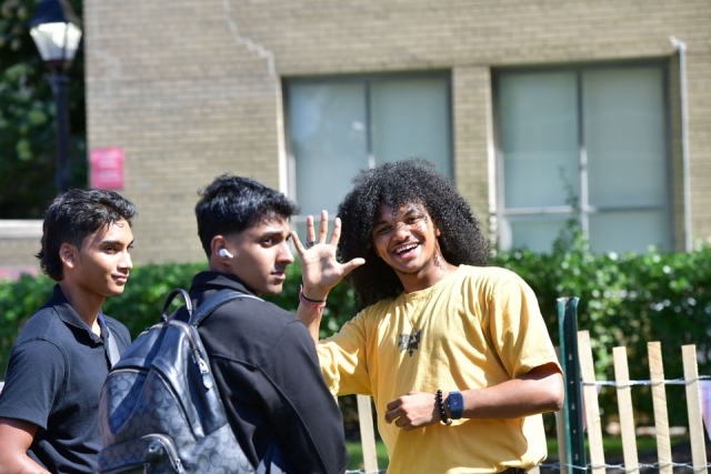 Three students outside standing
