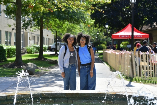 Two students walking by campus fountain