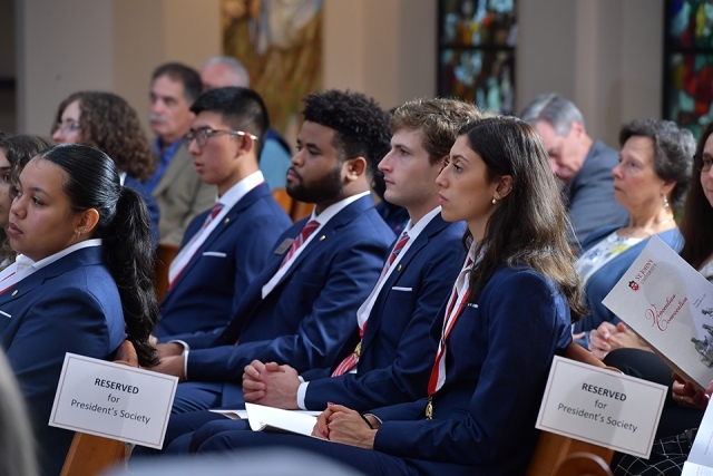President's Society members standing in pews