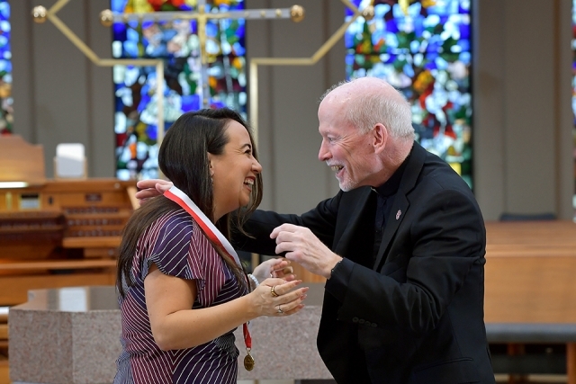 Female honoree and Fr. Shanley in church