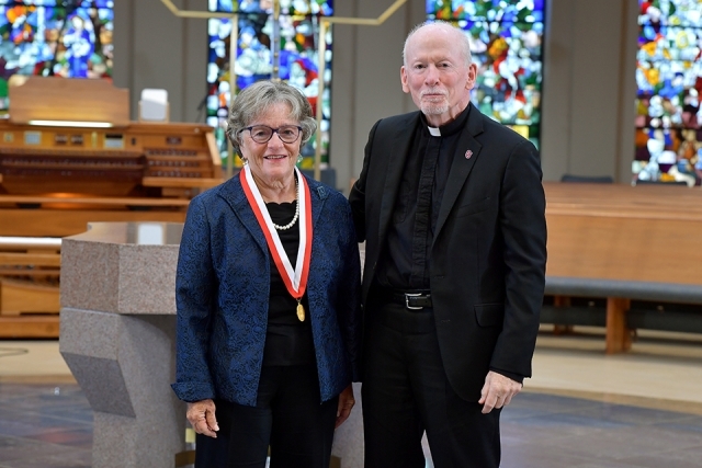 Female honoree and Fr. Shanley in church